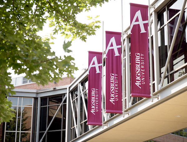 Augsburg University banners hang from a skyway on campus